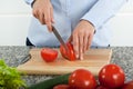 Cutting fresh red tomatoes on cutting board Royalty Free Stock Photo