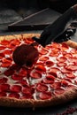 Cutting giant pepperoni pizza with special knife Royalty Free Stock Photo