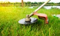 Cutting grass with brushcutter on sunny summer day. Lawn mowing on holidays. Royalty Free Stock Photo