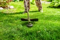 Cutting grass in the garden with a trimmer. Lawn improvement works in landscape design. Selective focus Royalty Free Stock Photo