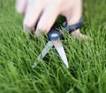 Cutting the grass with a pair of scissors Royalty Free Stock Photo