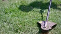 Cutting green grass with whipper snipper. Hand held grass trimmer mowing lawn. Grass shreds flying around in slow-mo