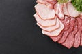 Cutting ham with vegetables assortment on black background Royalty Free Stock Photo