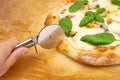 Cutting a homemade neapolitan style pizza on a parchment paper