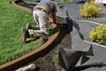 Concrete curb edging being troweled for smoothness in a flower bed Royalty Free Stock Photo