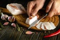 Cutting lard with a knife in the hands of a cook for setting the table for lunch or for a snack. Delicious lard with chasnok and