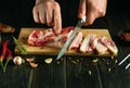 Cutting lard or undercut with a knife in the hand of a cook to prepare hearty sandwiches for a snack