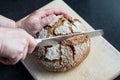 Cutting loaf of bread with knife on cutting board Royalty Free Stock Photo