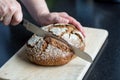 Cutting loaf of bread with knife on cutting board Royalty Free Stock Photo