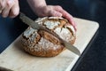 Cutting loaf of bread with knife on cutting board Royalty Free Stock Photo