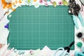 The cutting mat is surrounded by paper flowers, paper, tools and scrapbooking materials Royalty Free Stock Photo