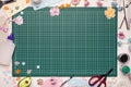 The cutting mat is surrounded by paper flowers, paper, tools and scrapbooking materials Royalty Free Stock Photo