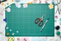 The cutting mat is surrounded by paper flowers, paper, tools and scrapbooking materials Royalty Free Stock Photo