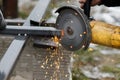 Cutting metal with angle grinder machine. Close up of circular grinder disc and electric sparks. Workers making fence with Royalty Free Stock Photo