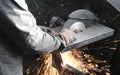 Cutting of metal. Closeup men`s hands cutting metal with a circular saw. Sparks fly to the side. Royalty Free Stock Photo