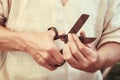 Cutting metal for making retro coins. Cuts silver with scissors to make money. Man hands close-up holding a big scissors