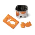 Cutting out a goldfish from fresh raw sweet winter carrot with a mold on white background