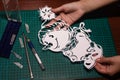 Cutting paper patterns snowing with a knife on a special rug. snowman out of paper Royalty Free Stock Photo