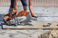 A worker cuts paving slabs with a diamond blade and a gas cutter on a clear summer day Royalty Free Stock Photo
