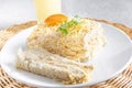 Cutting a piece of chilled savory chicken pie, a typical Brazilian dish. On the form of straw, gray wooden background. White plate