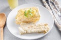 Cutting a piece of chilled savory chicken pie, a typical Brazilian dish. In white plate, gray wooden background. Next to a wooden