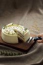 A piece of decadent cake with a sharp knife on a rustic wooden cutting board