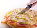 Cutting pizza with knife Royalty Free Stock Photo