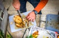 Cutting prepared rotisserie grilled fried chicken outside on piknik. Royalty Free Stock Photo