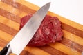 Cutting Raw Entrecote steak meat With Salt On Wooden Board in a kitchen with a knife isolated on white
