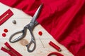 Cutting red fabric with a taylor scissors on wooden table Royalty Free Stock Photo