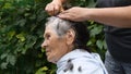 Cutting senior woman hair while staying home at quarantine