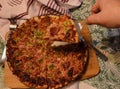 Cutting and separating a piece of freshly baked pizza