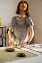 Cutting and sewing in tailor studio: sewer young woman work with fabric in design workshop studio