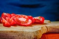 Cutting tomatoes. Red tomato slices on wooden cutting board. Royalty Free Stock Photo