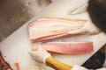 Cutting tuna fish on cutting board