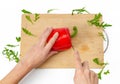 Cutting vegetables on kitchen board. Female hands cut bell pepper with a knife. White background Royalty Free Stock Photo