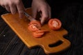 Cutting vegetables. Male hands cutting tomatoes on a cutting board. Royalty Free Stock Photo