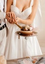 Cutting the wedding cake with flowers and macaroons Royalty Free Stock Photo