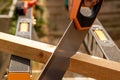 cutting wood with tenon saw on sawhorses