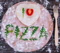 Cutting wooden board with traditional pizza ingridients on dark background, top view