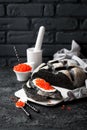 Cuttlefish ink bread and red caviar on black background Royalty Free Stock Photo