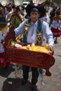 A man holding a cradle with baby Jesus and wearing traditional clothes during the Huaylia on Christmas day at the Plaza de Armas s