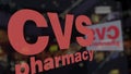 CVS Health logo on the glass against blurred business center. Editorial 3D rendering
