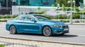 Cyan BMW 420D convertible F33 on the road in motion. Fast speed drive on city road. Front side view BMW 4 series Royalty Free Stock Photo