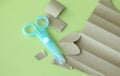 Cyan Plastic children safety scissors on table with brown paper in different shape Royalty Free Stock Photo