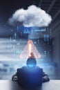 Cyber attack and hacking concept with front view on faceless hacker in hoody typing on laptop and abstract digital data cloud Royalty Free Stock Photo