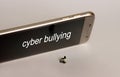 `cyber bullying` Text on Smart Phone Screen. A sitting miniature woman and a Smart phone. Royalty Free Stock Photo