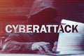 Cyberattack concept, hooded computer hacker working on laptop, glitch effect added in post Royalty Free Stock Photo