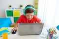 Boy in headphones playing video game on laptop Royalty Free Stock Photo