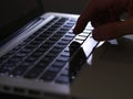 Cybercrime - one finger on lighted keyboard